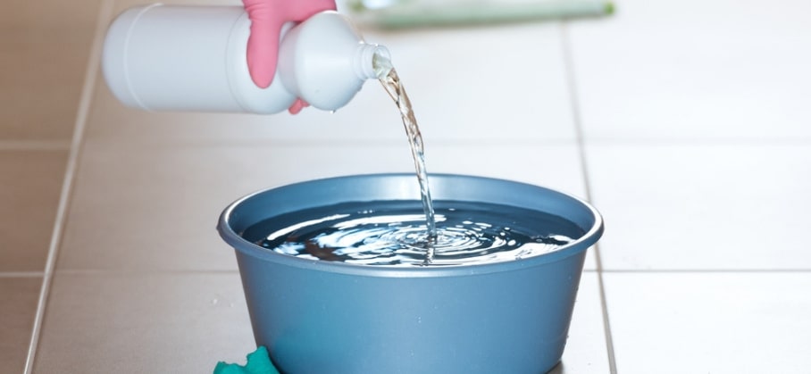 Woman mixing bleach with another cleaning detergent.