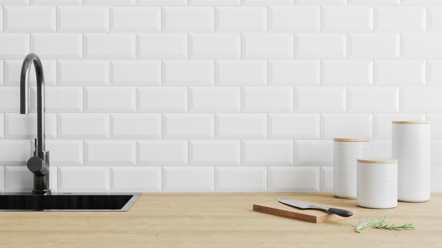 Clean white kitchen tiles and a black sink