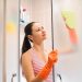 A woman cleaning shower glass door with ease.