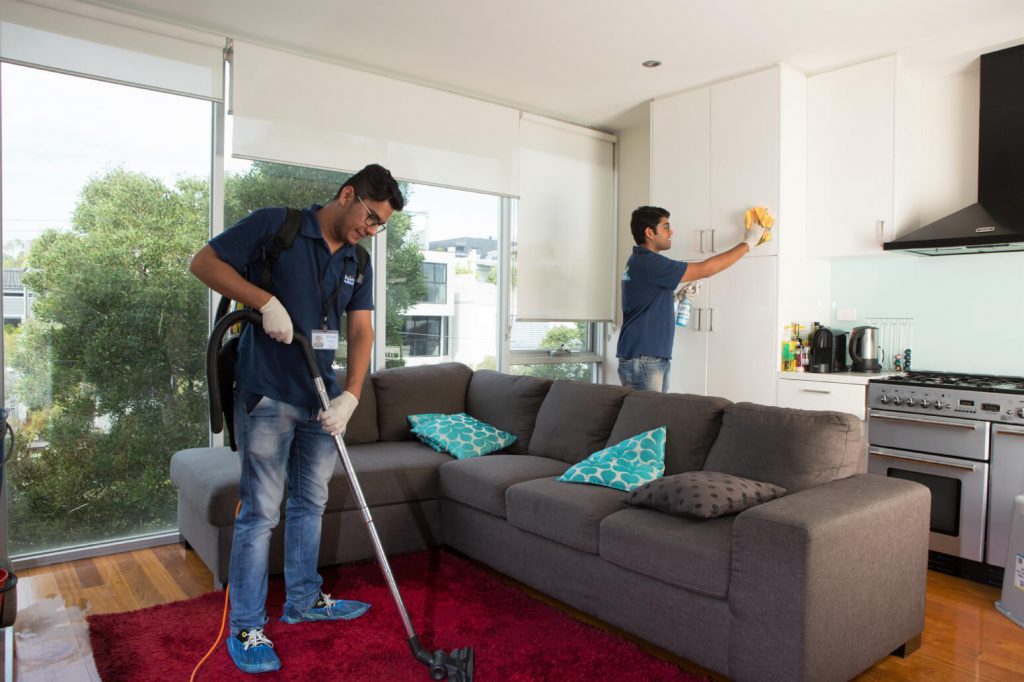 End of lease cleaning professionals cleaning a living room