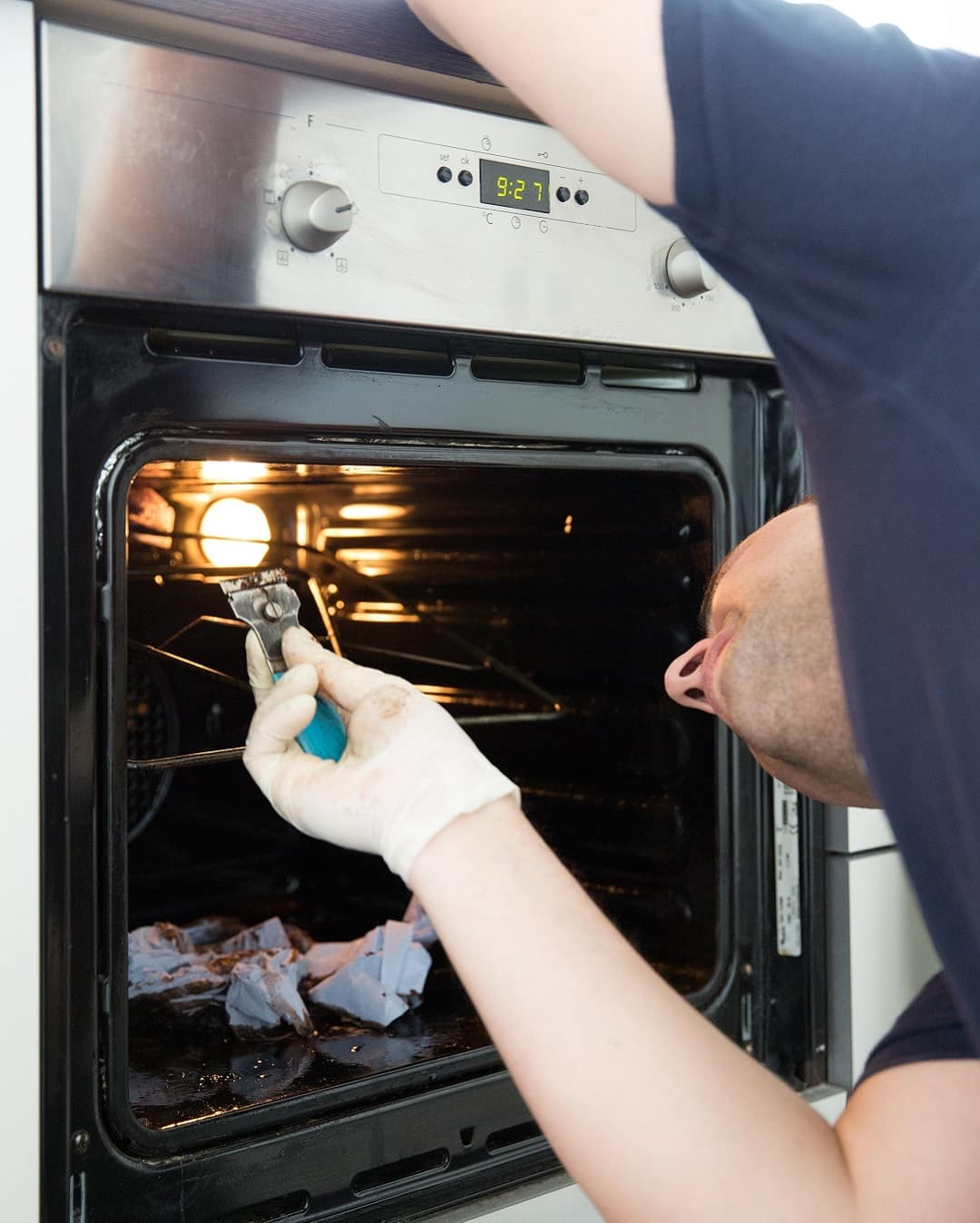 Professional cleaner performing oven cleaning